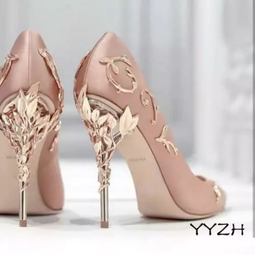 Pair of pink high-heeled shoes with gold detailing 
